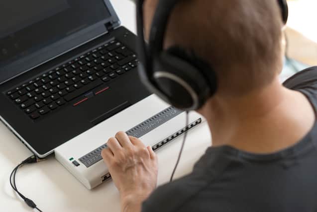 Global Accessibility Awareness Day focuses on digital access and inclusion for people with disabilities or impairments. (Image shows visually impaired person working on computer with assistive technology)