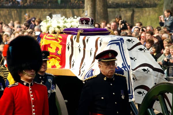 Soldiers accompany a gun carriage holding the coffin bearing the Queen Mother April 5, 2002.