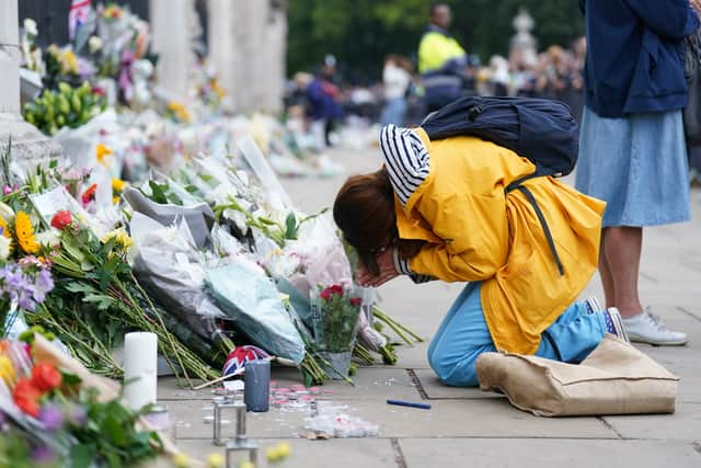 A woman is upset outside Buckingham Palace, London, following the death of Queen Elizabeth II on Thursday September 8, 2022. Picture date: Friday September 9, 2022.