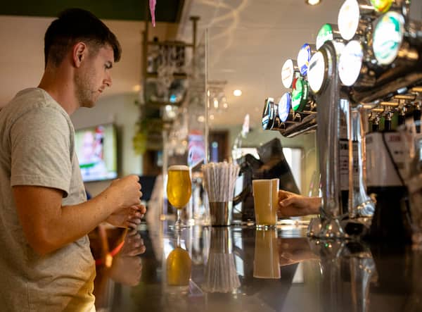 <p>A customer buys a drink at a Wetherspoons pub in Clapham, London.</p>
