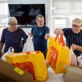 Volunteers sort food into food parcels at a community charity.  