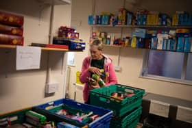 A worker at the Coventry Foodbank centre in Queens Road Baptist Church collates donated food items into parcels that will be provided to people arriving with a foodbank voucher.