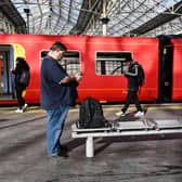 Commuters walk past a train stopped at a platform in Waterloo Station in London, during a national strike day, on February 1, 2023.