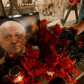  A man lays flowers at a makeshift memorial in honour of Yevgeny Prigozhin.