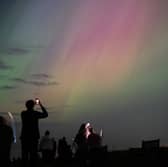 People visit St Mary's lighthouse in Whitley Bay to see the aurora borealis on 10 May 2024 (Photo: Ian Forsyth/Getty Images)