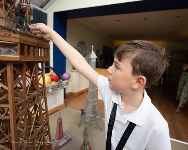 Charlie Barratt, aged 8, measures himself against his Tower replica.