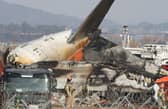 Firefighters check near the wreckage of a passenger plane at Muan International Airport 