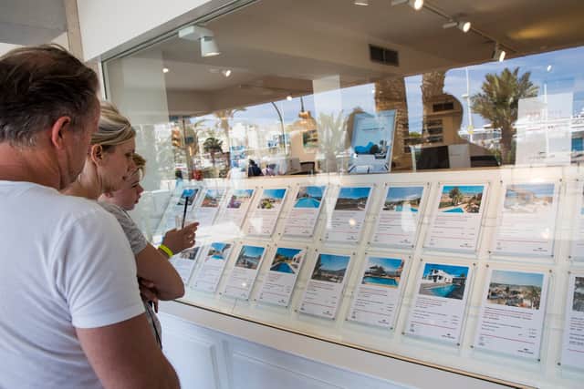 Tourists look at apartments in the window shop of a real estate on the island of Ibiza (Photo: JAIME REINA/AFP via Getty Images)