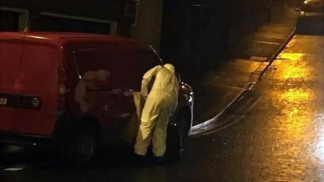 Police officers and forensic teams conduct investigations at a flat in Market Street, Keady