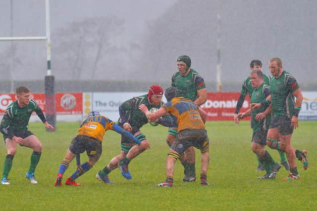 City of Derrys Stephen Carr battles through the conditions and Bangor players at the Craig Thompson Stadium on Saturday afternoon last. DER0720GS - 021