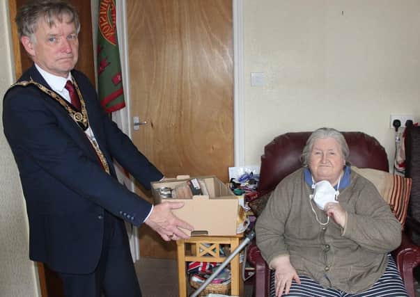 The Mayor of Causeway Coast and Glens Borough Council, Councillor Mark Fielding, delivers a package to Anne Marie Gault, during his visit to Millburn Community Association. Pic: McAuley Multimedia
