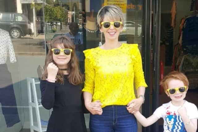 Banbridge Cancer Focus NI charity shop manager Melissa Faulkner and her children Grace and Harry model the free sunglasses you can find at the store while stocks last. #careinthesun