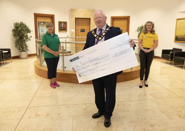 Mayor of Antrim and Newtownabbey, Alderman John Smyth presents a cheque for £12,000 to representatives of his two nominated charities; Lisa Hendley of Alzheimer's Society and Sarah Clements of Cancer Fund for Children.