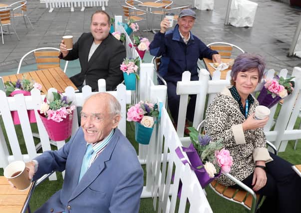 Promoting the availability of alfresco dining Alderman Jim Dillon MBE, Development Committee Chairman and Councillor Nathan Anderson are joined by Harry Staniland and Ruth Timpany, father and daughter who were enjoying their first coffee together in 14 weeks.