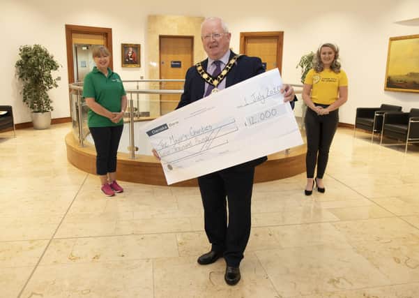 Mayor of Antrim and Newtownabbey, Alderman John Smyth presents a cheque for £12,000 to representatives of his two nominated charities; Lisa Hendley of Alzheimer's Society and Sarah Clements of Cancer Fund for Children