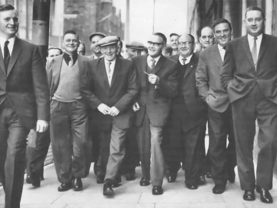 Shipyard workers arriving at the Grosvenor Hall in Belfast in May 1965 to attend a mass meeting to discuss the labour dispute which had lead to a two week strike. More than 3,500 men were made idle because of the dispute between the Boilermakers Society and management. By the end of the meeting it had been agreed that it was back to work, a decision which the News Letter noted was welcomed by both sides of the strike. (NEWS LETTER ARCHIVES)