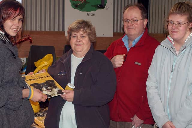 Dogs Trust volunteer Alsion Reed sells a callender to Margaret Gough, Leonard Punter and Leaanne Punter at the recent Dogs Trust Christmas Fair. BT49-(810)H