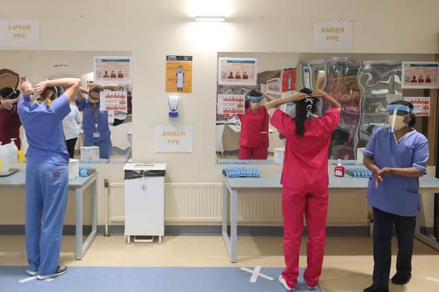 Nurses practice social distancing while donning PPE at Craigavon Area Hospital in Co Armagh, Northern Ireland.