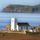 Digging potatoes near Ballintoy Parish Church in August 2011 with Bull Point on Rathlin Island as a backdrop as viewed from the McHenry farm. Picture: Kevin McAuley