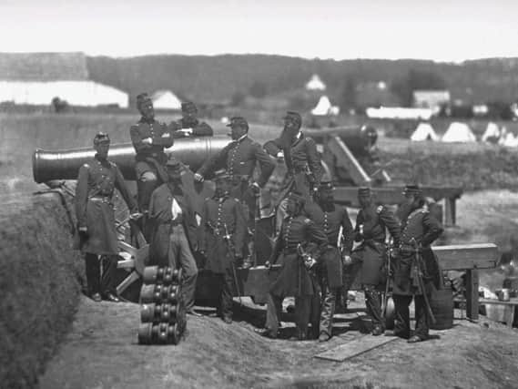 Union soldiers pose for a photograph with a cannon during the American Civil War, one of the earliest true industrial wars. Railroads, the telegraph, steamships, and mass-produced weapons were employed extensively
