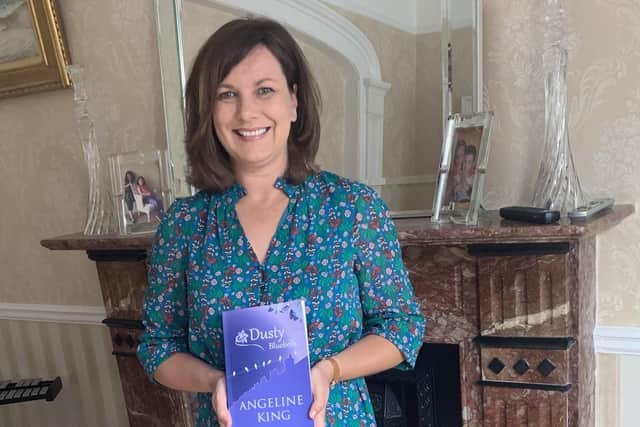 Angeline King holds a copy of her new book, Dusty Bluebells.