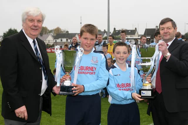 Corey Price and Nial Toner, of Ballymena United Youth Academy, presents their trophies to Robert Couples and Norman McBurney. BT40-258AC