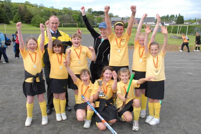 The victorious Larne and Inver Primary School team celebrate  with coach Mrs Waide and principal Mr Holmes after winning the Larne Primary Schools Hockey Tournament held at Larne High School. LT21-371-PR
