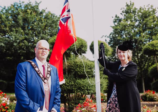 Mayor of Antrim and Newtownabbey, Cllr Jim Montgomery looks on as Deputy Lieutenant for County Antrim, Mrs Julia Shirley raises the Red Ensign to mark Merchant Navy Day 2020.