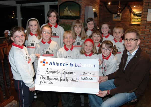 Children from Cairncastle Primary School present Jerome Quinn with a £1400 cheque for Leukaemia Research, raised with a sponsored silence at the school, before he took part in the Can't Cook, Won't Cook event at the Halfway House Hotel. LT49-355-PR