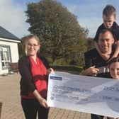Accepting a cheque on behalf of Charis handed over by Angela McCabe's husband Frank and children Emma and Michael.
