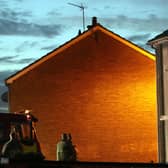 Fire officers survey the charred windows of the house in the Ballykeel estate, Ballymena where a 12 year old girl died in a fire on Wednesday night. Picture: Pacemaker