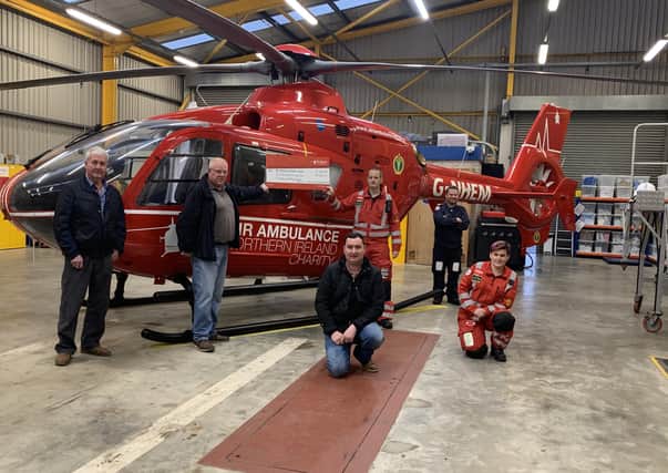 Braid Valley Vintage Enthusiasts committee representatives - Sammy Millar, John Crothers and Brian Millar presenting the donation to members of the Air Ambulance NI operational team