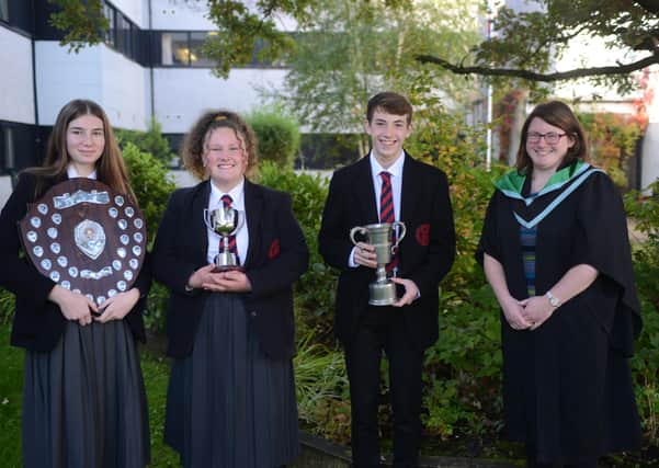 Ellie Gould, Emily Clugston and Owen Beckington being congratulated on their achievements by Head of Year 11, Mrs Montgomery.