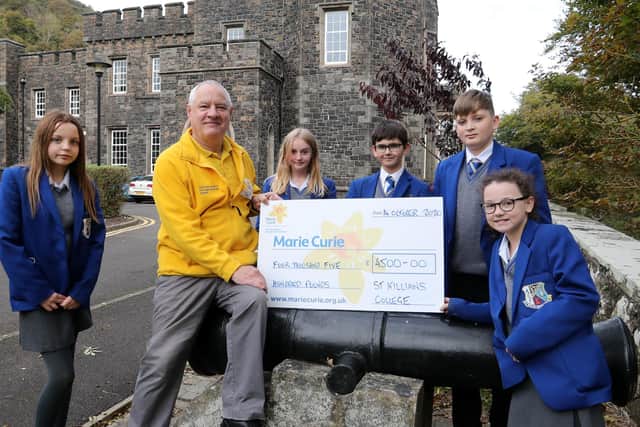 Year 8 pupils who took part in the walk presenting Phil Kane from Marie Curie with a cheque for £4500.