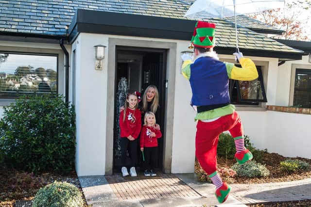 Nikki, Tianna (8) and Tahlia (3) Taggart enjoying Jingle the Elf delivering an Elfagram to their door