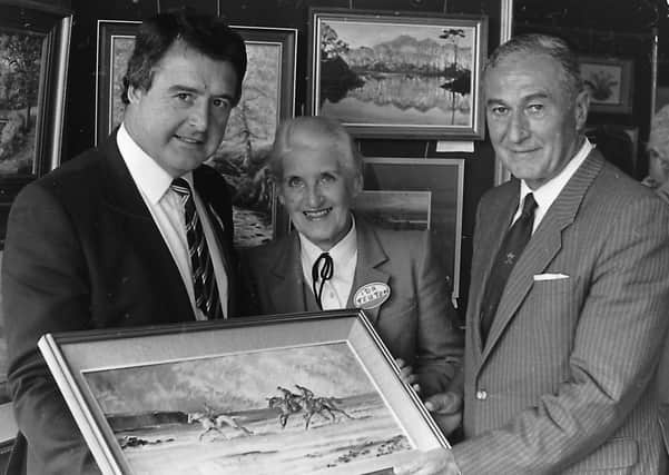 Admiring a painting by Lady Kinahan at the Collegians Art Show in October 1987 are Peter Jones, president of the club, artist Ida Teuton and Willoughby Wilson, president of the Ulster Branch of the Irish Rugby Football Union. Picture: News Letter archives