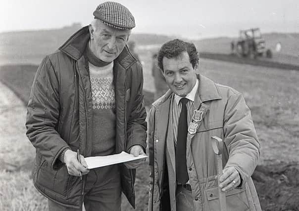 Judges Harold Simms and G Huey check the depth of a furrow at the ploughing championships at Bushmills, Co Antrim, in November 1987. Picture: Randall Mulligan/Farming Life archives