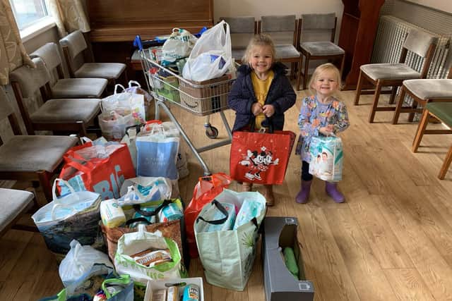 Five-year-old Elliana and three-year-old Adalie Lynn helping with the harvest collection at Rathcoole Presbyterian Church.