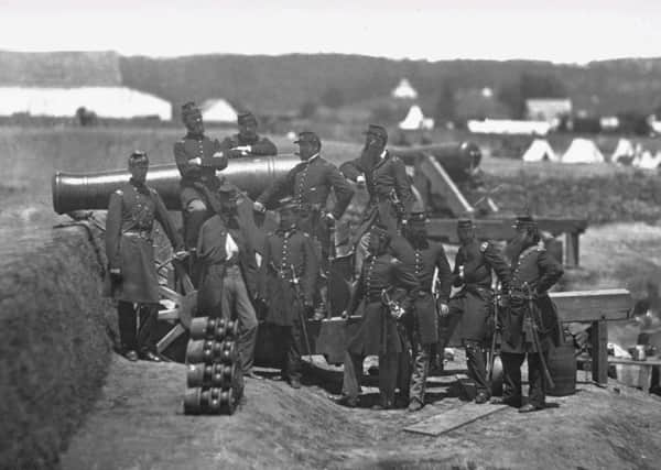 Union soldiers pose for a photograph with a cannon during the American Civil War.  one of the earliest true industrial wars. Railroads, the telegraph, steamships, and mass-produced weapons were employed extensively
