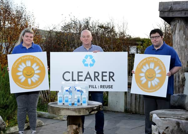 David Hunter (centre), CEO of Access Employment Limited and co-founder of Clearer is pictured with employees Nicole Gant and Ryan Spence with the new range of hand sanitiser, which is bottled at its Larne-based factory.