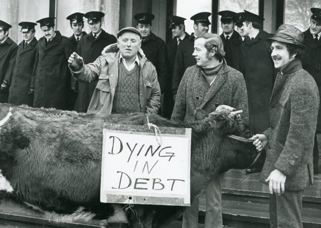 Member of the RUC lined up at the entrance to Dundonald House in east Belfast in January 1975 while farmers held a good humoured mock auction of the cow which was in the vanguard of their protest. Picture: News Letter archives