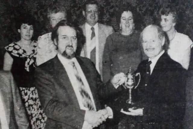 Members of Dunclug PTA look on as Mr F. McPherson presents Mr Noel Clarke with the Stanley Herbison Trophy.1989