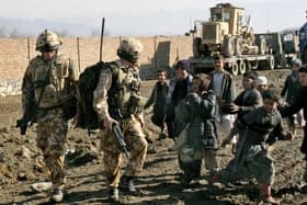 British soldiers of the NATO-led forces meet a group of Afghan boys during a routine foot patrol in Kabul, Afghanistan in February 2007. Picture:  AP Photo/Musadeq Sadeq