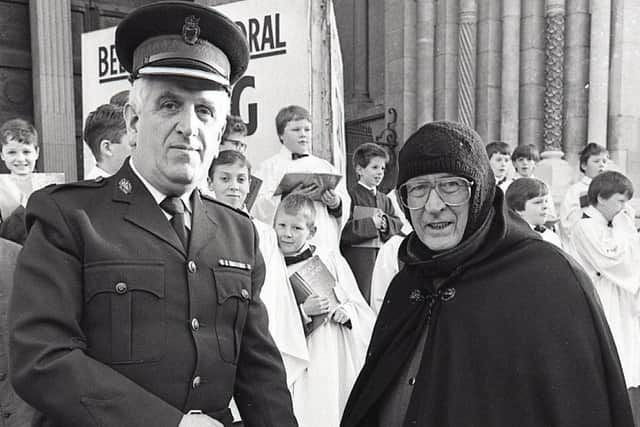 Superintendent Bob Catterson, commander of the RUC's Belfast Mobile Support Unit, starts Dean The Very Reverend Jack Shearer's charity collection off with a £300 cheque outside St Anne's Cathedral in December 1998. The Dean told the News Letter: “You can stick the cold weather, but the wet windy days are the worst.” Mr Shearer was in his third year of collecting funds as the Black Santa, he was carrying on the annual tradition started by Dean Samuel Crooks, who pioneered the Christmas sit-out back in 1976. Picture: News Letter archives