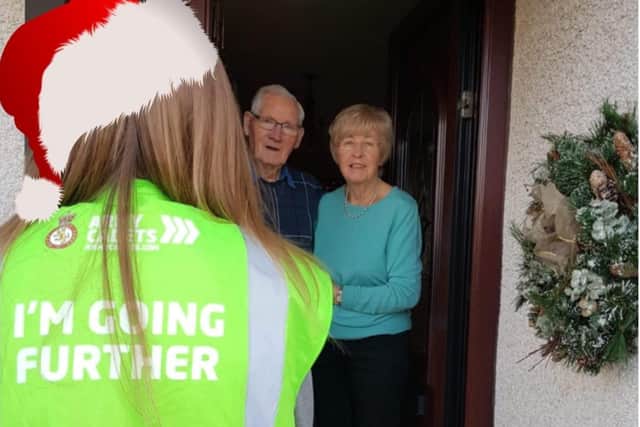Pictured is Cadet Ellen Robinson delivering a Christmas gift to Evergreen members, Sam and Sally Wilson from Islandmagee.