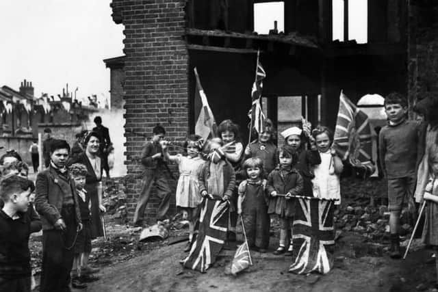 London residents celebrating VE-Day, (Victory-in-Europe Day) marking the end of the war in Europe, amidst the ruins of their home in Battersea, in May 1945. Picture: PA Wire