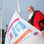 Mayor of Antrim and Newtownabbey, Cllr Jim Montgomery, pictured with the Union Flag, Ulster Banner and the council's Centenary flag.