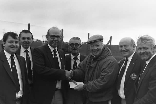 Samuel Hutton, chairman of the South Belfast Northern Ireland Supporters' Club presents a cheque to Billy Bingham to help cover the costs of a youth coaching course in October 1989, watched by Jack Johnson, left, John Davis, Alex Hamilton, Hugh Wilson and Roy Millar, IFA youth development officer. Picture: News Letter archives