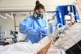 Clinical staff wear Personal Protective Equipment (PPE) as they care for a patient