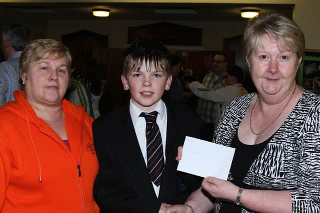 Anna Benton and Valerie Getty of the Cullybackey High School Parents’ Association present a sponsorship cheque to pupil Robert McAuley to help with his expenses when competing in the Boys Golf Championships in Dublin. BT49-114JC